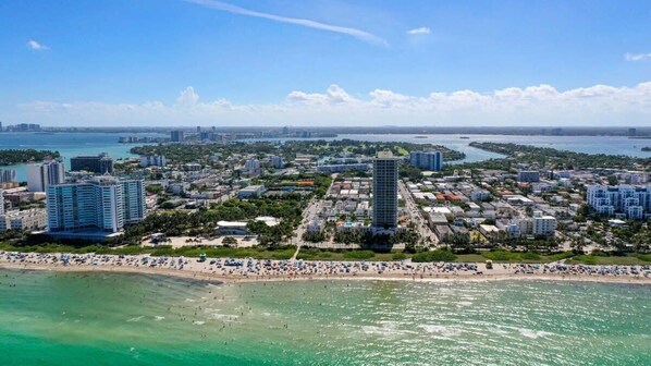 An aerial view of a coastal city with high-rise buildings, a beach, and a marina. - Beach Bae, Bright Studio, Steps to the Ocean (Miami Beach)
