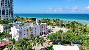 A hotel with a pool, surrounded by palm trees and a view of the ocean. - Beach Bae, Bright Studio, Steps to the Ocean (Miami Beach)