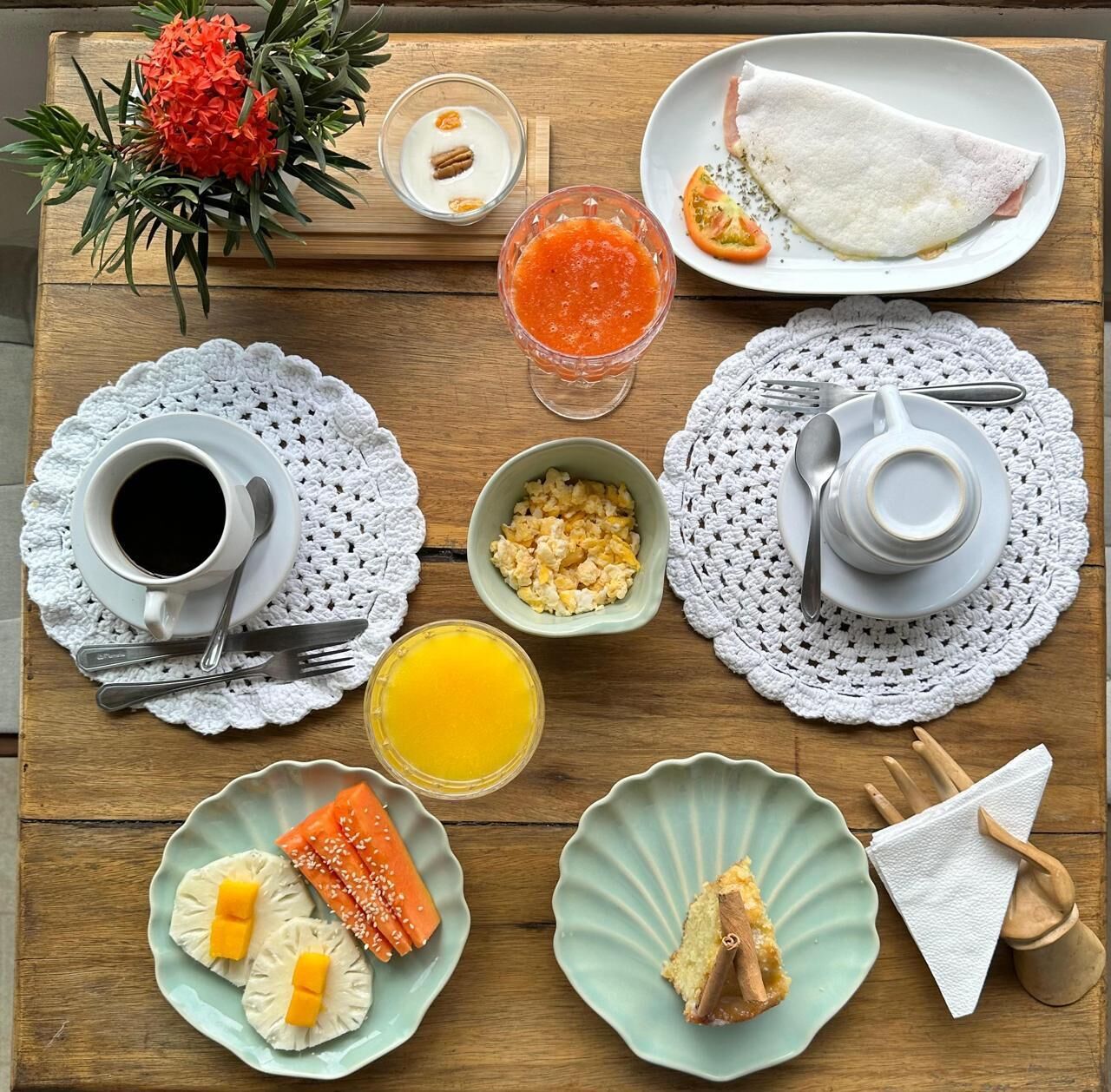 A breakfast table with various dishes including eggs, toast, and a fruit salad.