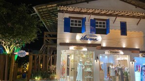 Ett litet, exklusivt hotell som heter ”Morena”, med en butiksfasad där skyltdockor i klänningar visas upp och en skylt som anger hotellets namn.