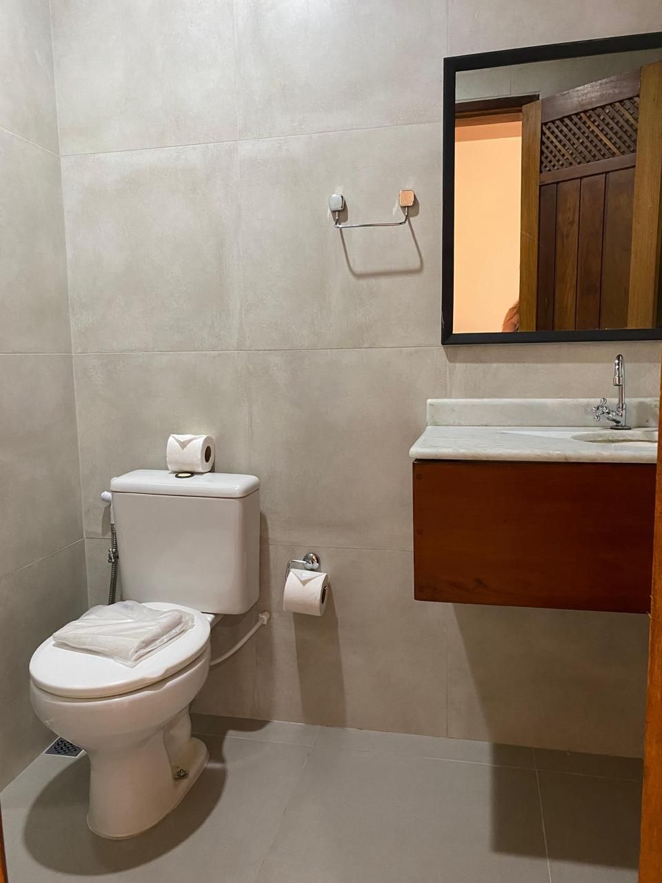 Ein Badezimmer mit Toilette, Waschbecken und Spiegel.