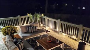 Eine Terrasse mit einer Sitzecke, einem Couchtisch und einem Blumentopf.