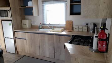 Departamento, varias camas | Cocina privada | Refrigerador, microondas, horno y parrilla de estufa