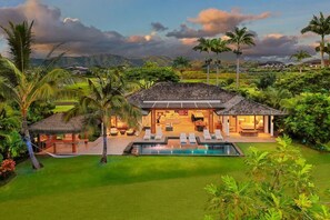 A house with a pool, outdoor seating, and a thatched-roof structure. - Luxury Home w/heated pool: Mehana Makai (Koloa)
