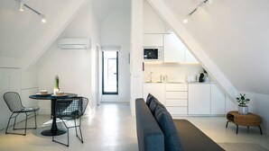 A modern loft apartment with a dining area, kitchen, and living space. - Portaria Housing (Aveiro)