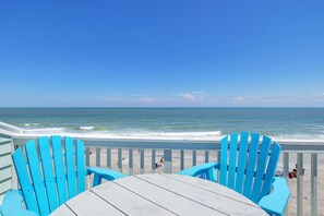 A beach view with two blue Adirondack chairs and a wooden table. - Seaside Vista, Luxury Oceanfront, Top "2nd" Floor, Amazing Views!! (Kure Beach)