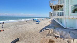 A beach with a lifeguard tower, umbrellas, and beach chairs. - Seaside Vista, Luxury Oceanfront, Top "2nd" Floor, Amazing Views!! (Kure Beach)