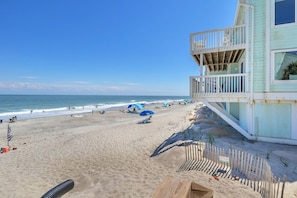 Une plage avec un poste de surveillance pour les sauveteurs, des parasols et des chaises de plage.