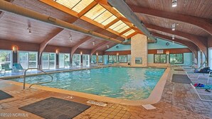 An indoor swimming pool with a high ceiling, clear windows, and lounge chairs. - Seaside Vista, Luxury Oceanfront, Top "2nd" Floor, Amazing Views!! (Kure Beach)