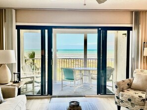 A hotel room with a large sliding glass door leading to a balcony with a view of the beach. - Sandcastles Direct Oceanfront Lovely-2 bedroom Condo-Perfect! (Cocoa Beach)
