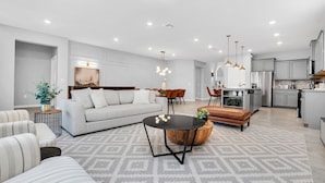 Un salon moderne avec un canapé, une table basse et un coin repas.