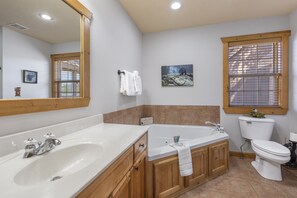 Enjoy a relaxing soak in the bathtub, paired with a separate sink and vanity area.