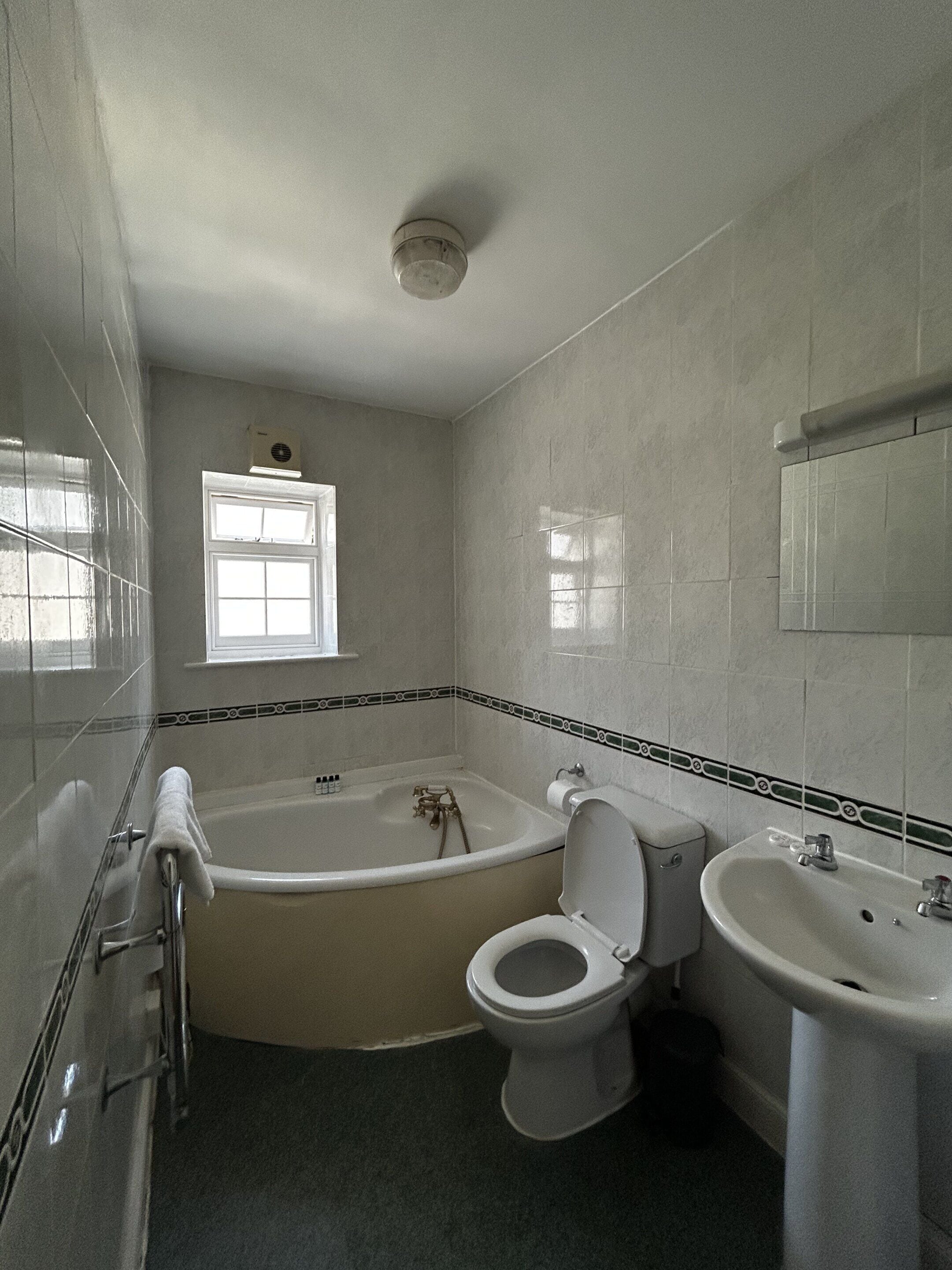A bathroom with a bathtub, toilet, and sink.