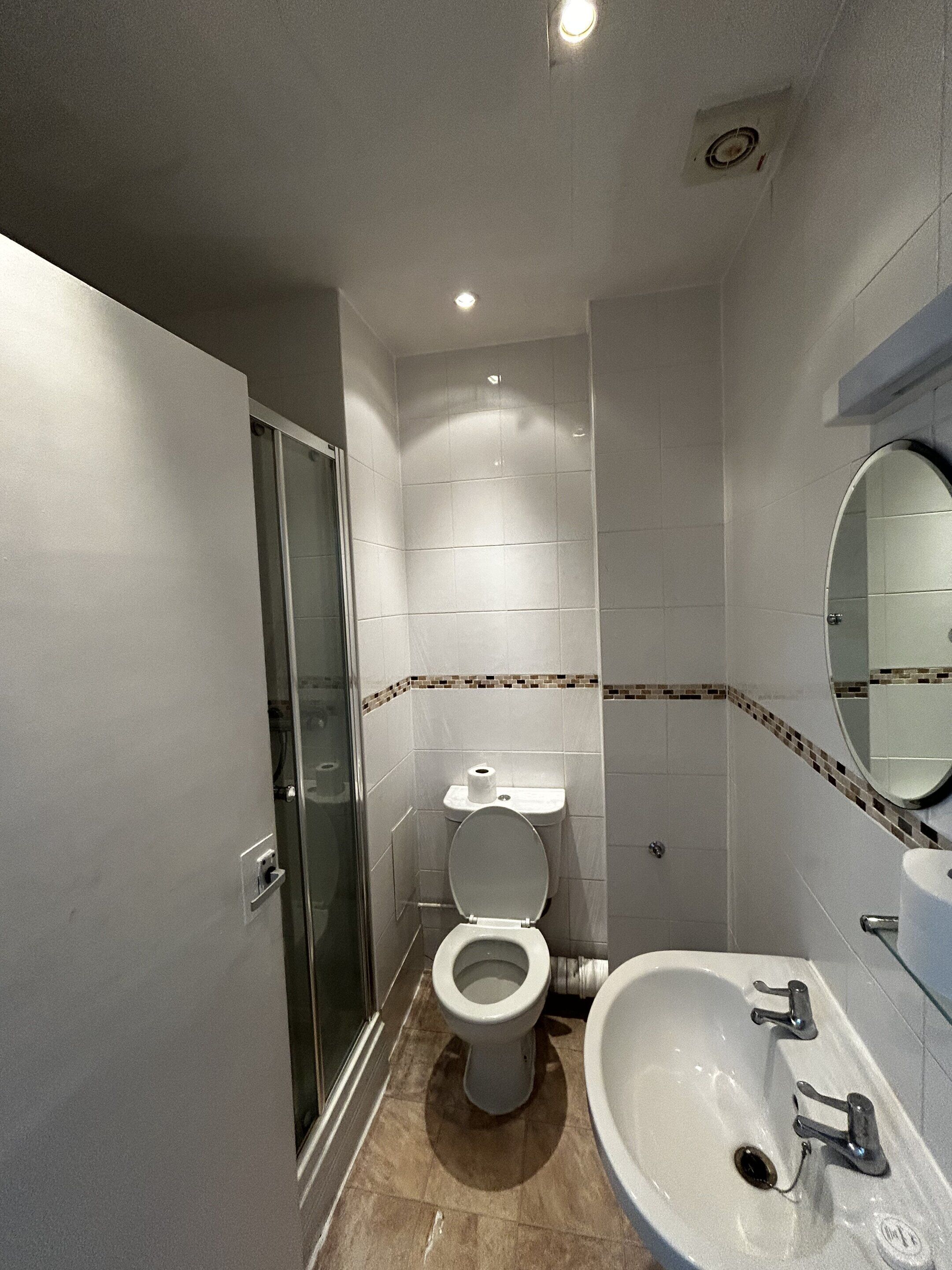 Un bagno piccolo con il water, lavandino e doccia.