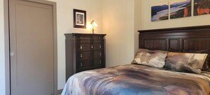 A bedroom with a bed, a dresser, and a door. - Beautiful Space in the Heart of NW Portland's Alphabet District (Portland)