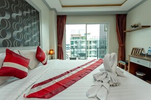 Relax in a stylish room with a large bed, desk, and window offering a view of the city.