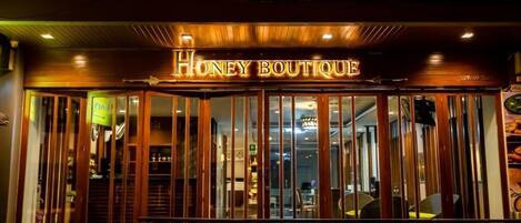 The exterior of Honey Boutique with a wooden facade and glass doors.