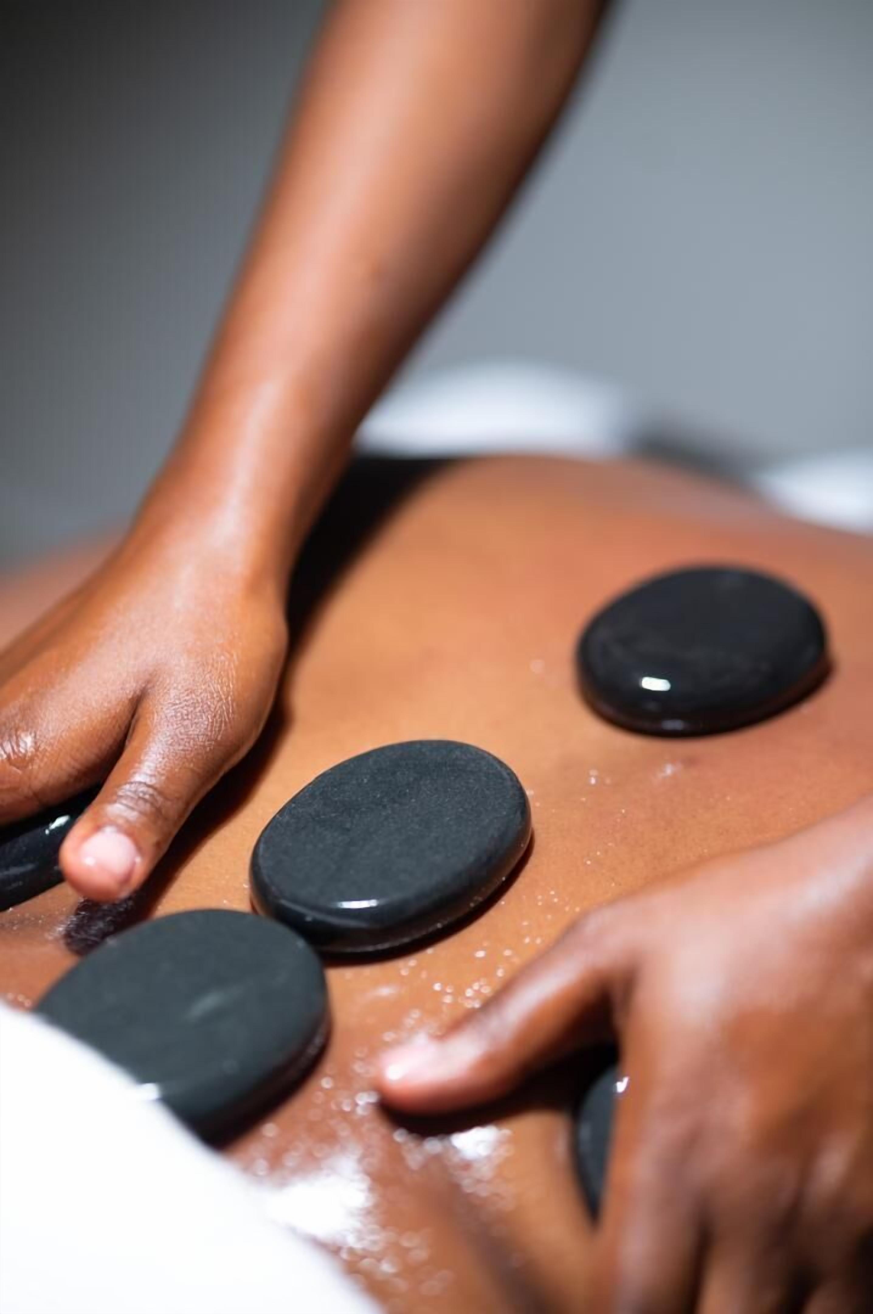 A massage table with black circular objects, likely for therapeutic purposes.
