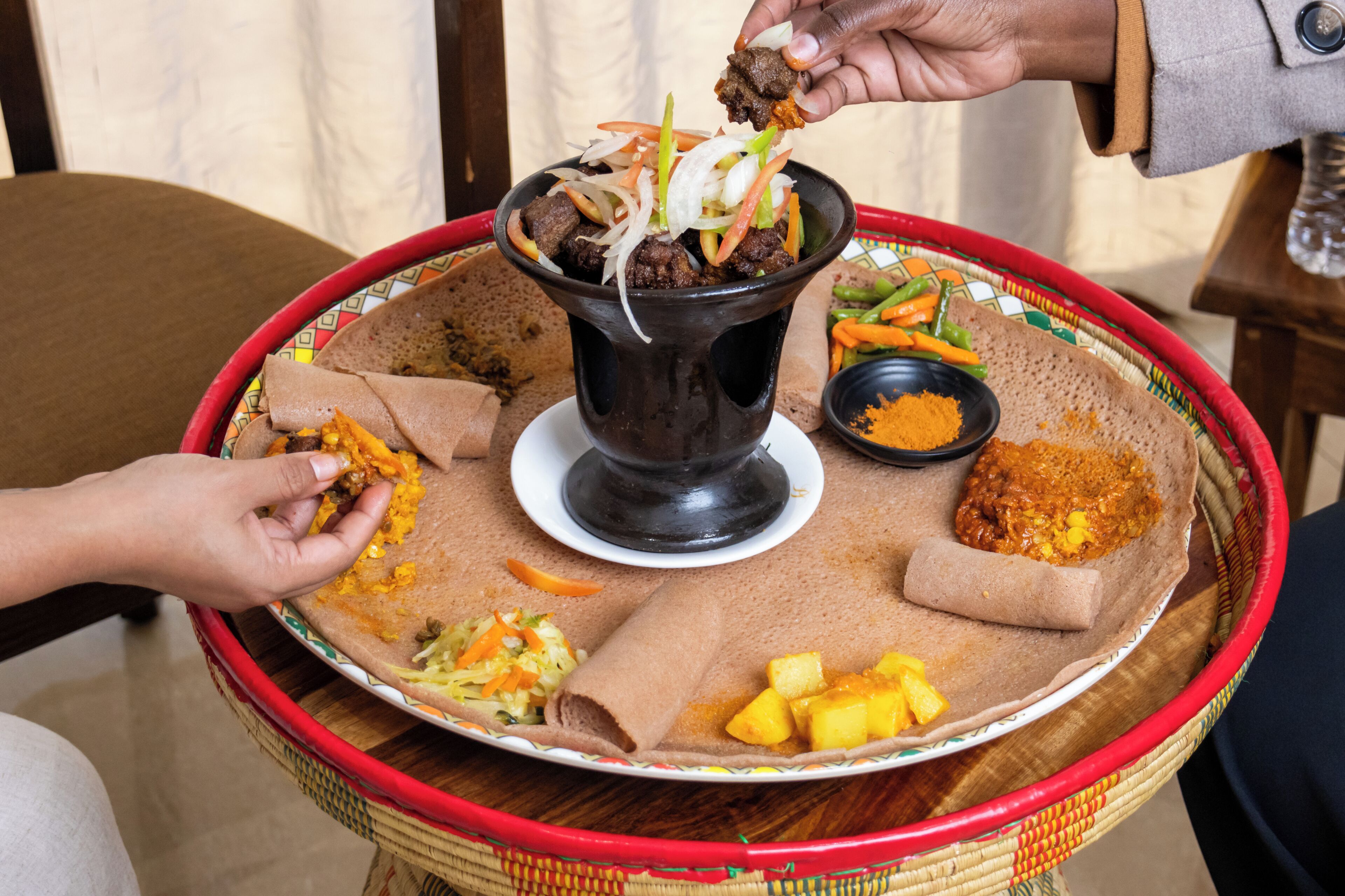 Un repas traditionnel éthiopien composé d’injera, de ragoûts et d’une variété de plats d’accompagnement.