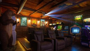 A log cabin-style room with plush reclining chairs, a large plush animal, and arcade games. - Disney Explorer - Sauna, Theater, Arcade and More! (Garden Grove)