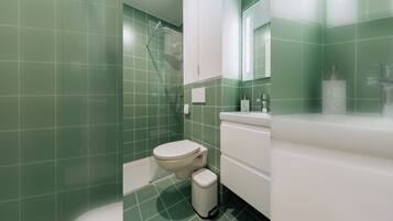 Ein Badezimmer mit Toilette, Waschbecken und Duschbereich.