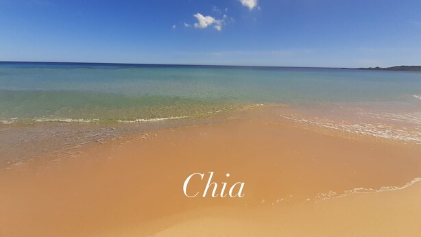 Une plage avec une eau turquoise cristalline et un rivage sablonneux.