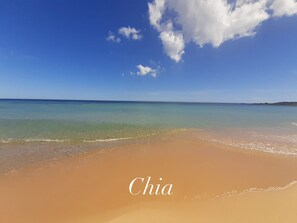 Ein Strand mit klarem türkisblauem Wasser und einem sandigen Ufer.