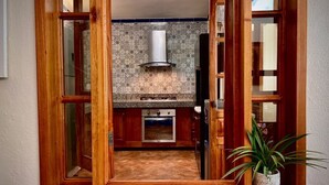 A kitchen with a stone countertop, a built-in oven, and a backsplash with a geometric pattern.