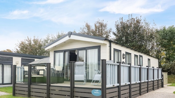 A mobile home with a covered patio area, a sliding glass door entrance, and a sign indicating "Yealands 3". - 3 Yealands (Carnforth)