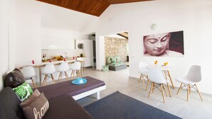 A modern living room with a sofa, dining area, and kitchen. - Family villa with heatable pool (Albufeira)