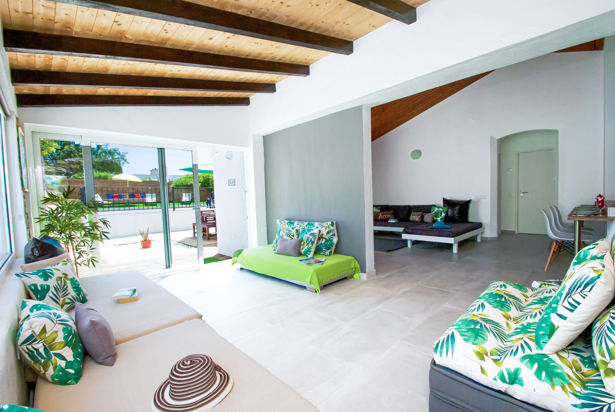 A modern interior with a sofa, a bed, and a dining area.