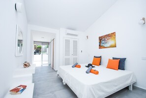 Ein modernes Schlafzimmer mit einem Bett, einem Nachttisch, einem Spiegel und einer Tür, die auf einen Balkon führt.