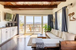 A modern living room with a sofa, a coffee station, and a TV. - The Leeds Cabin: A Civilization Escape + Hot Tub (Joshua Tree)