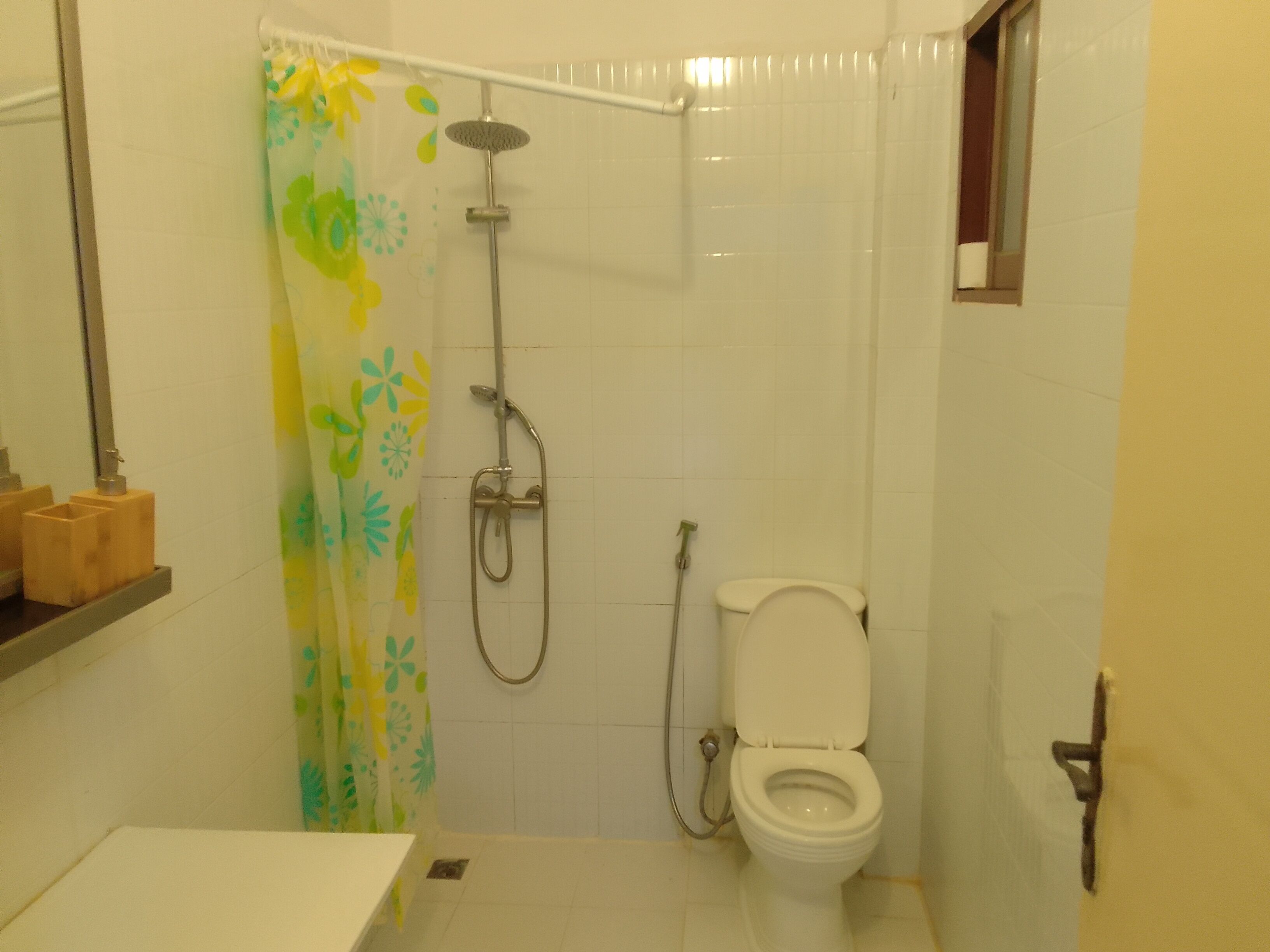 A bathroom with a shower, toilet, and a sink.