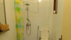 Un baño con ducha, inodoro y lavamanos.