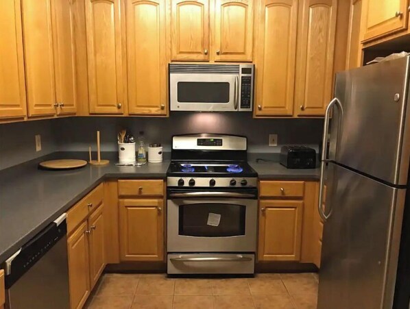 Fully equipped kitchen with microwave, gas range, and dishwasher.