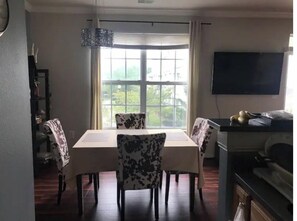 Enjoy meals in this dining area with a table for four, surrounded by a window with a view of lush greenery and a flat-screen TV.