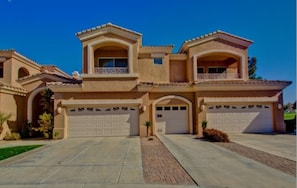 A two-story house with a symmetrical facade, two garages, and a central entrance.