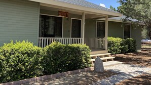 A two-story building with a porch, a sign reading "Wilkinson's Sunrise Cottage," and a stone monument in the front yard.