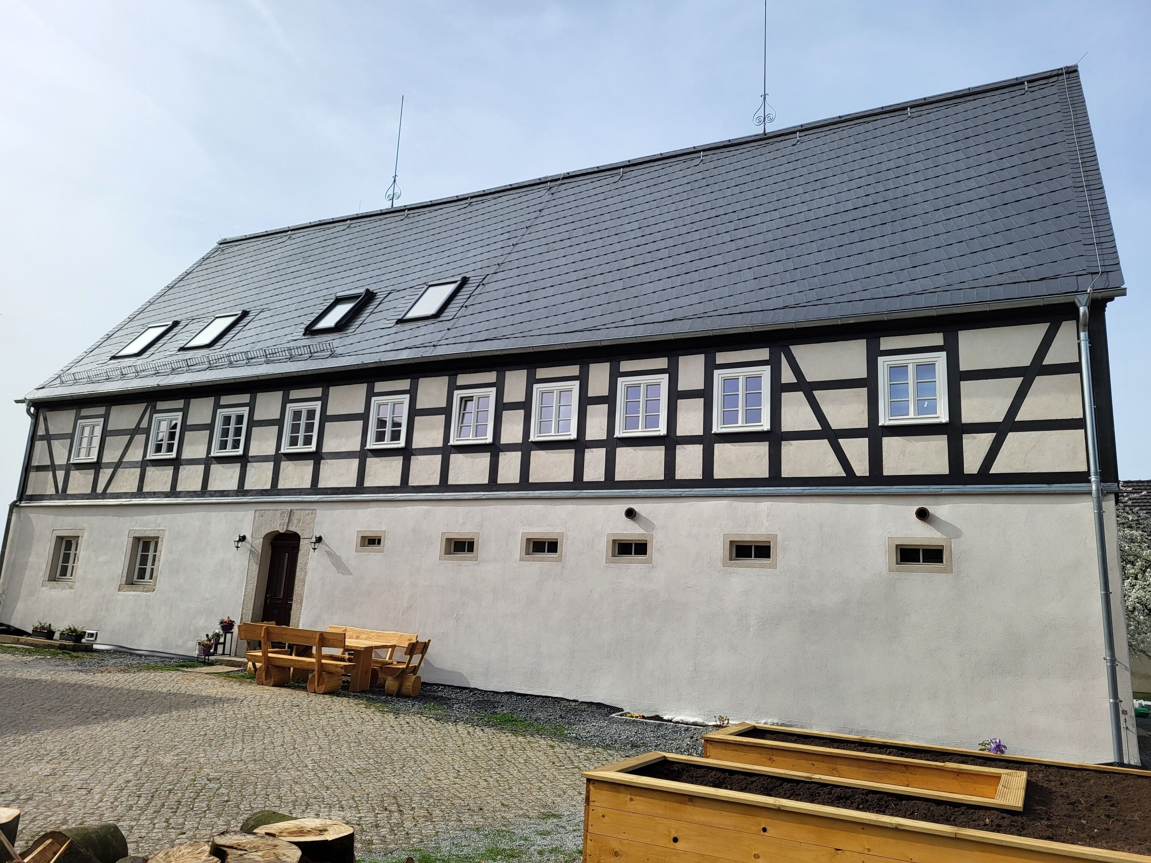 Ein traditionelles Fachwerkhäuschen mit vielen Fenstern und einem geneigten Dach.