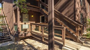 A multi-level wooden structure with a staircase, enclosed balconies, and a small window.