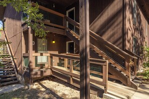 Eine mehrstöckige Holzkonstruktion mit Treppe, überdachten Balkonen und einem kleinen Fenster.