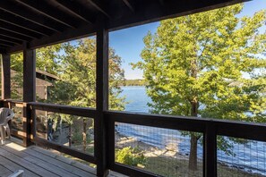 Una terraza de madera con vista a un lago y árboles.