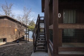 Una escalera de madera que lleva a un edificio con un amplio ventanal y el número '0' en la pared.