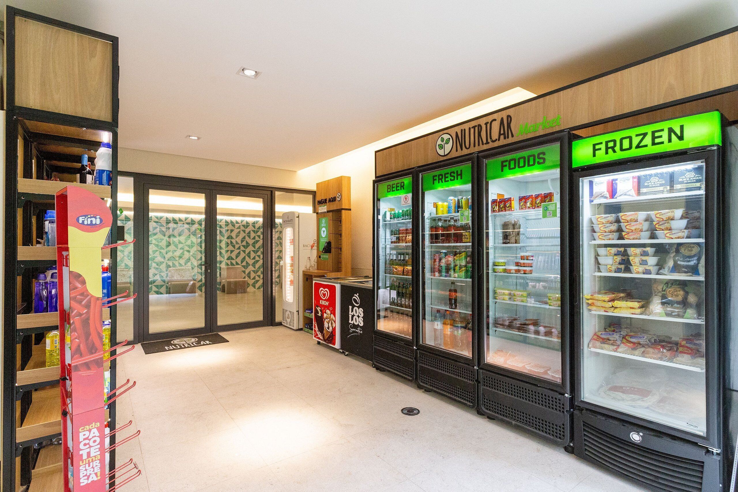 A food court with refrigerated display cases labeled "Beer," "Fresh Foods," and "Frozen."