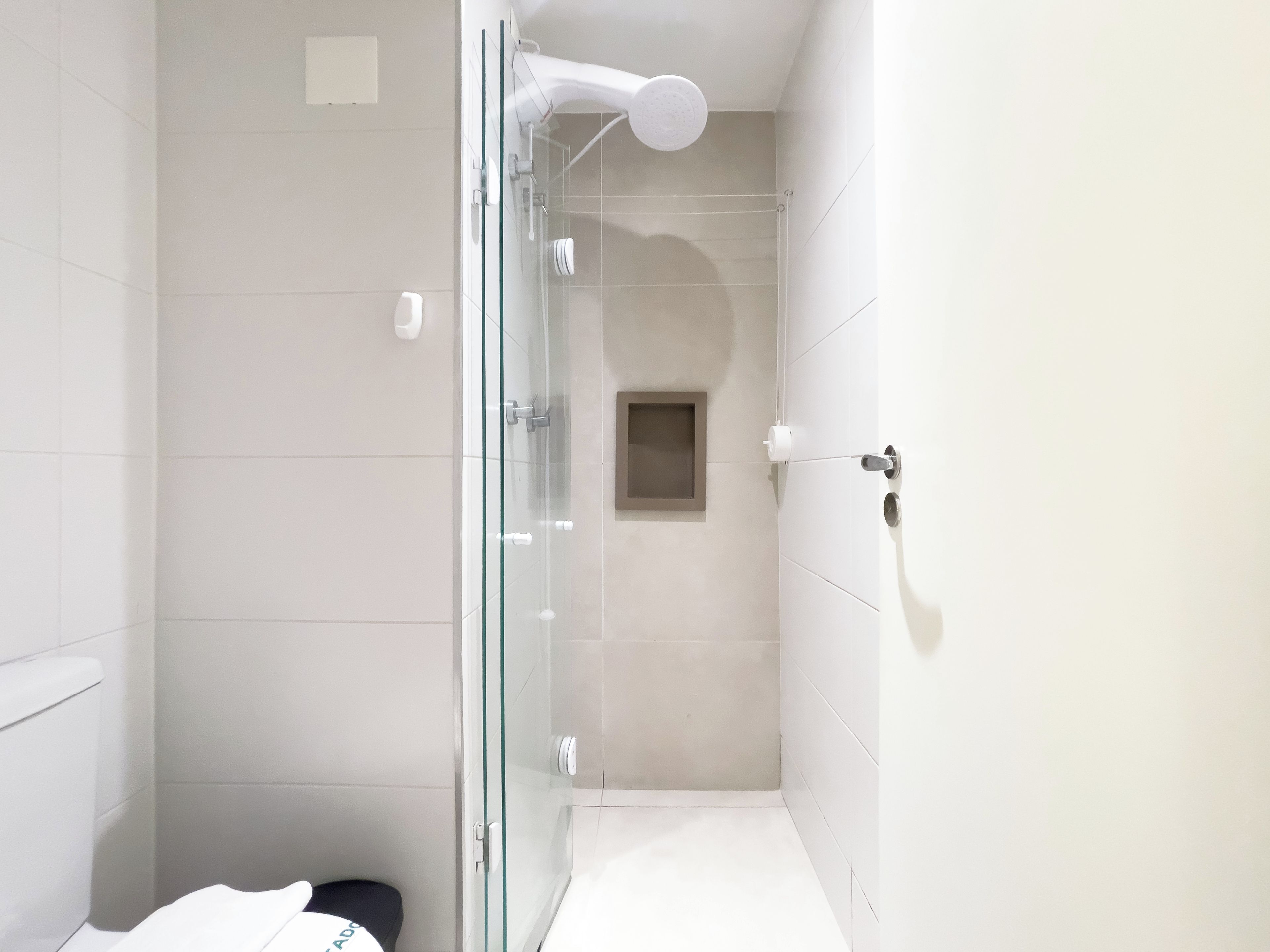 Een moderne badkamer met een douchecabine van glas, een toilet en een wastafel.