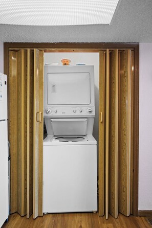 A compact room with a washing machine and a television. - Lone Oak Point 28 - Two Bedroom Apartment, Sleeps 6 (Sunrise Beach)