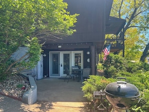 Ein Holzhaus mit überdachter Terrasse, einem Grill und einer US-amerikanischen Flagge.