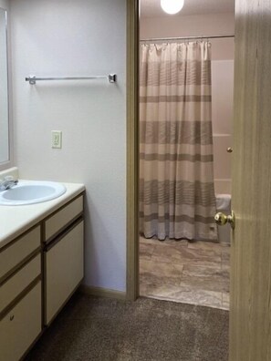 Een douche, handdoeken, zeep, toiletpapier