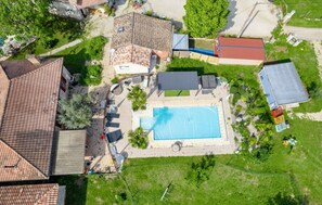 An aerial view of a residential area with a swimming pool, houses, and a small garden. - The blackbird's nest with sauna and jacuzzi. (Septfonds)